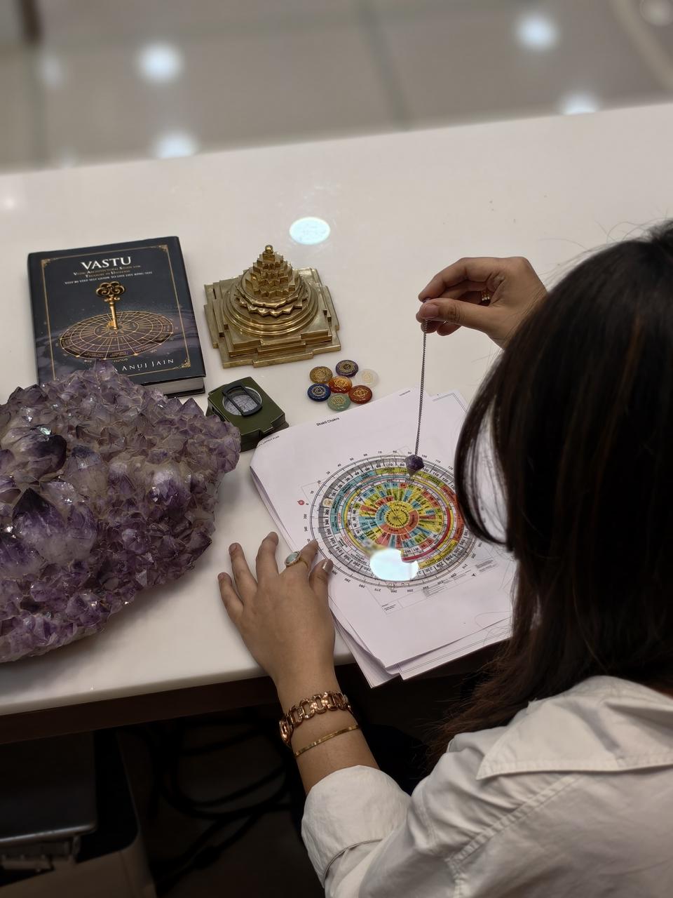 Sri Yantra, pendulum and Vastu chart on a consultation table