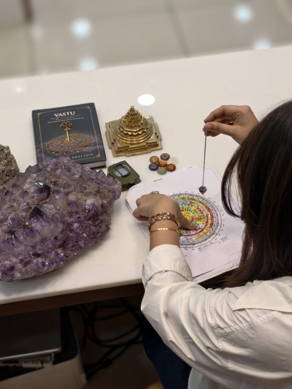 Close-up of a Vastu chakra chart being read with a pendulum
